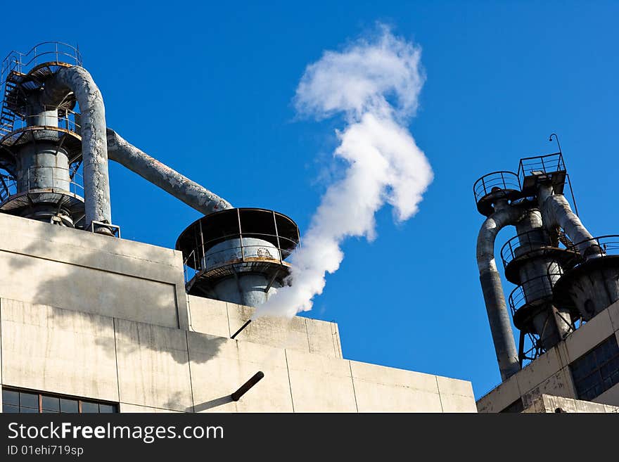 Industry stream above an old facility, with blue sky background. It shows that the factory is still running. Photo taken at 798 Art Zone,, Beijing, in January of 2009. RAW format available if needed