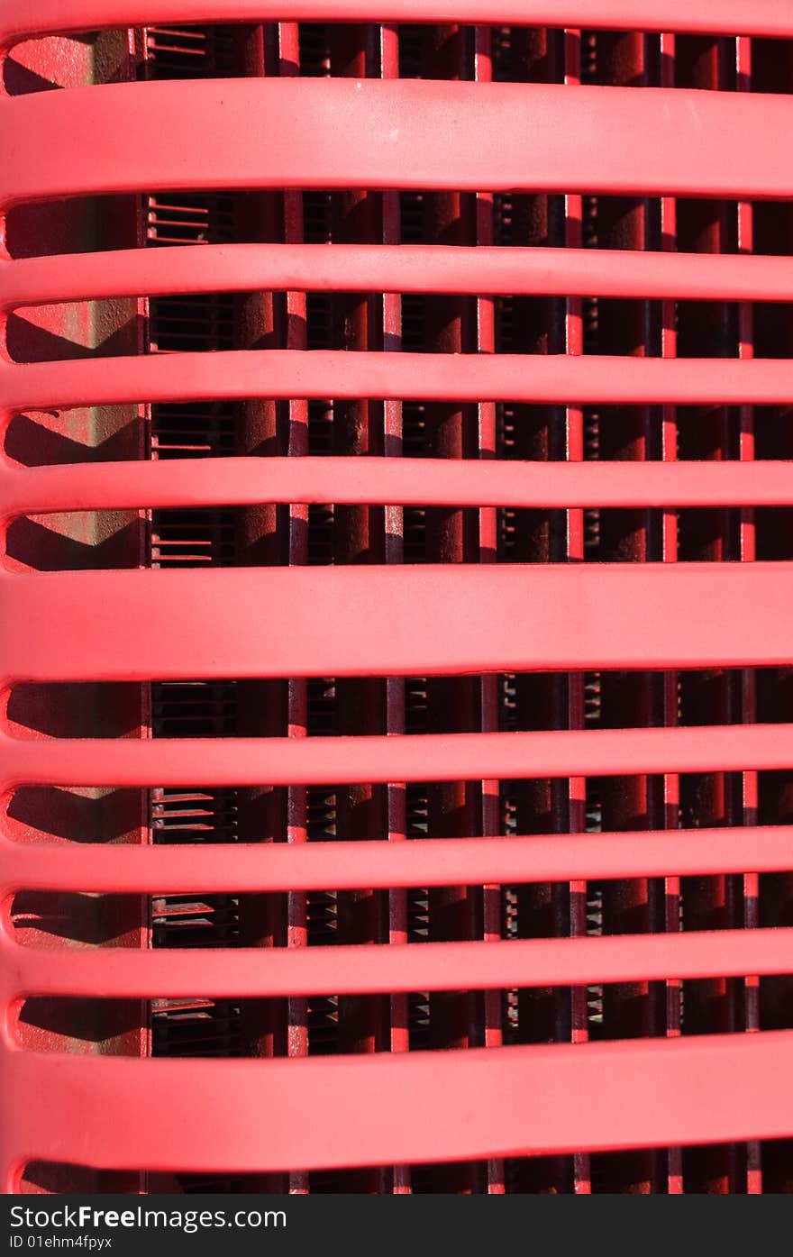 Red grill fins closeup from front of old vintage tractor.  Painted red stamped steel. Red grill fins closeup from front of old vintage tractor.  Painted red stamped steel.