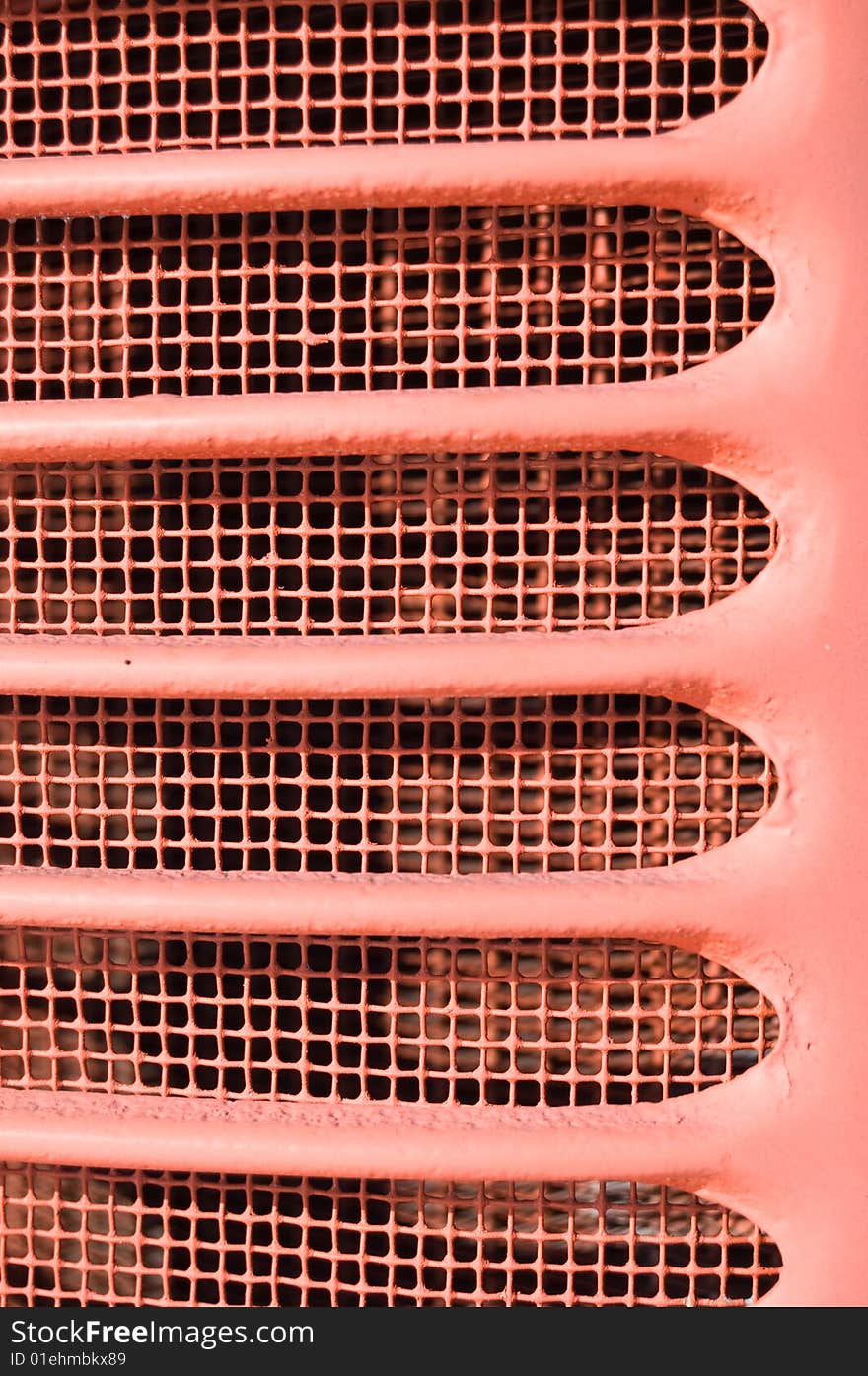 Red grill fins closeup from front of old vintage tractor.  Painted red stamped steel. Red grill fins closeup from front of old vintage tractor.  Painted red stamped steel.