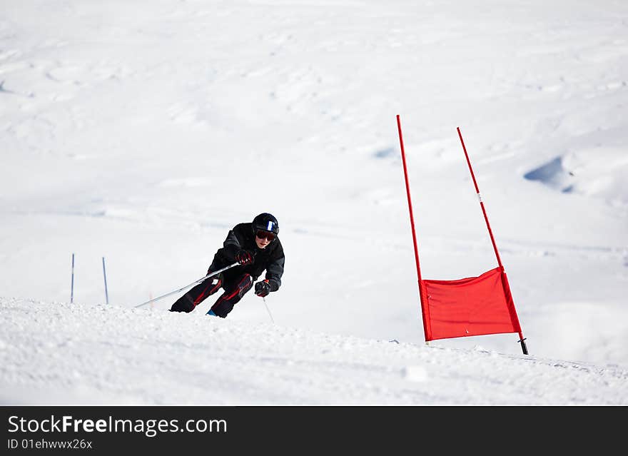 Young skier doing downhill on Giant Slalom course; horizontal orientation, large copy space. Young skier doing downhill on Giant Slalom course; horizontal orientation, large copy space.