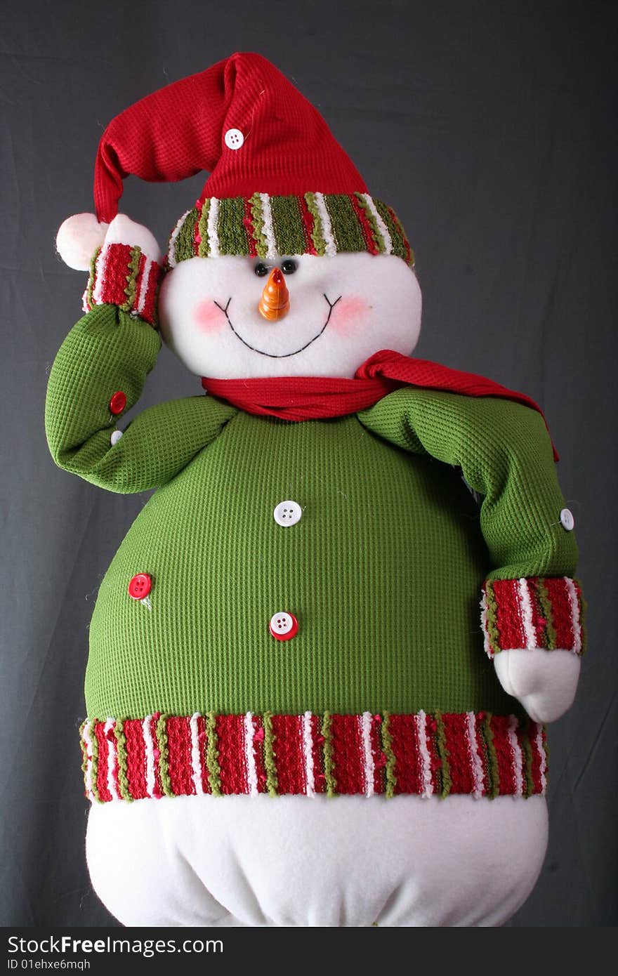 A posing snowman with green and red hat and jacket