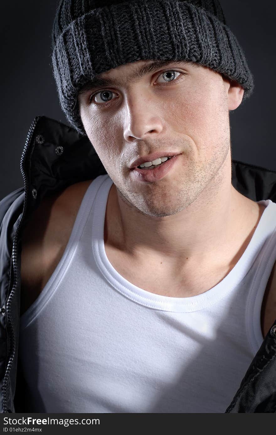 Fashion portrait of young smiling man in hat