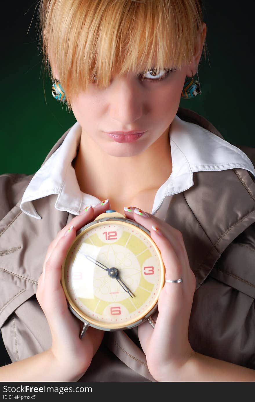 Beautiful woman with alarm clock on a black background