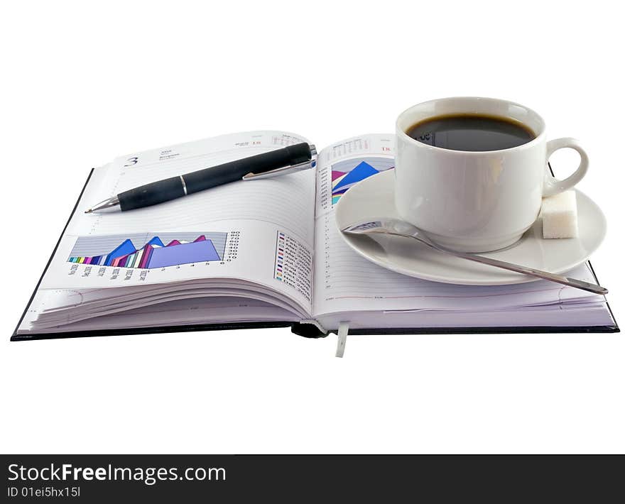 Coffee cup, pen, standing on  personal organizer.