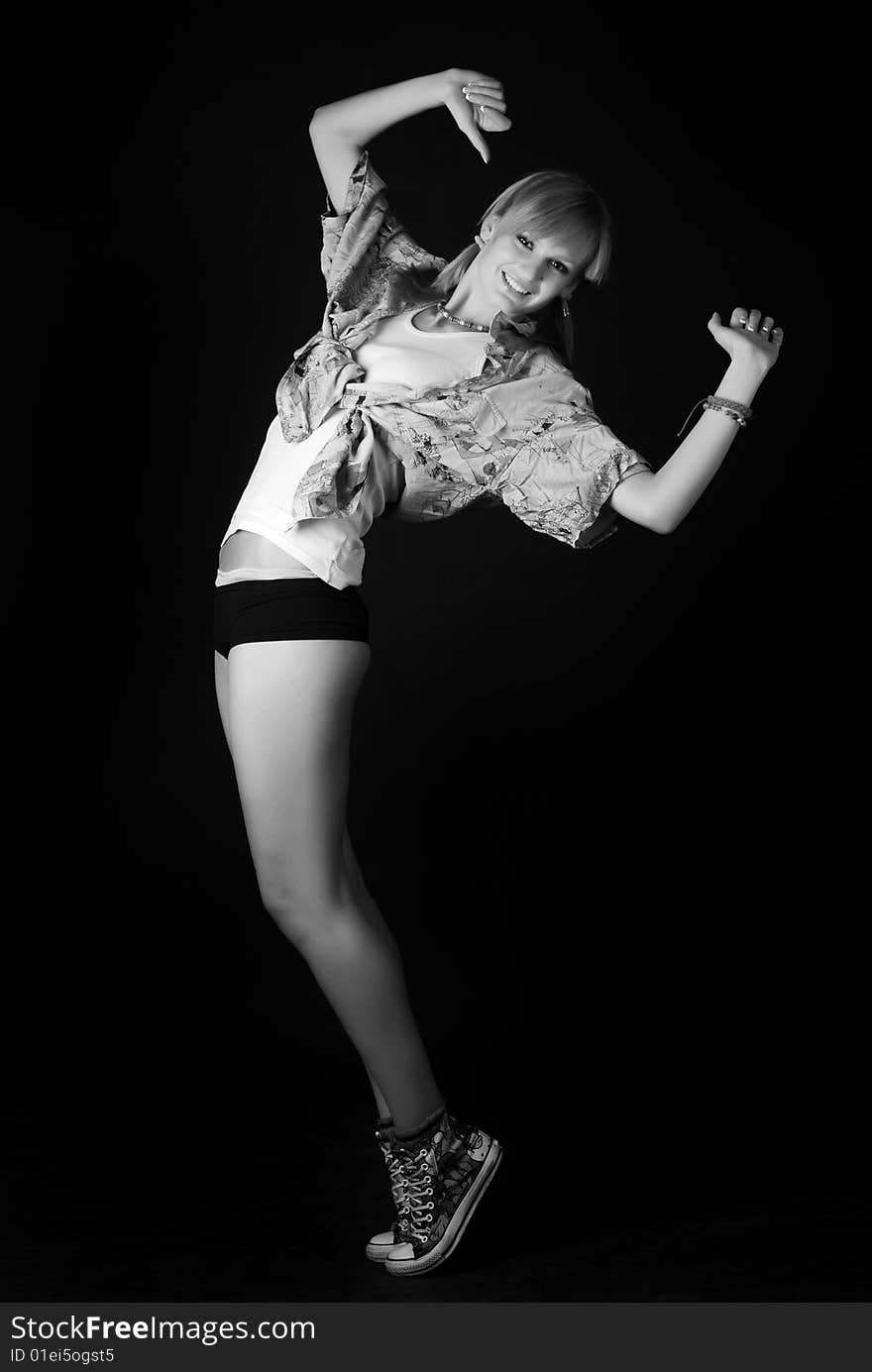 Beautiful young dancer jumping on a black background