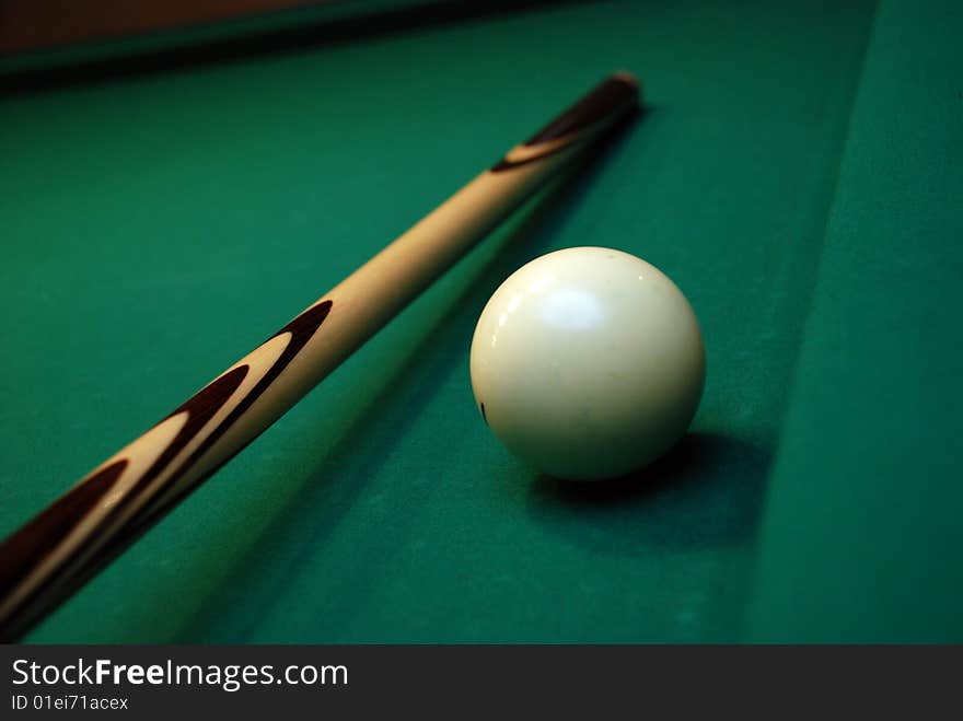 Picture of green billiard table with white ball and cue