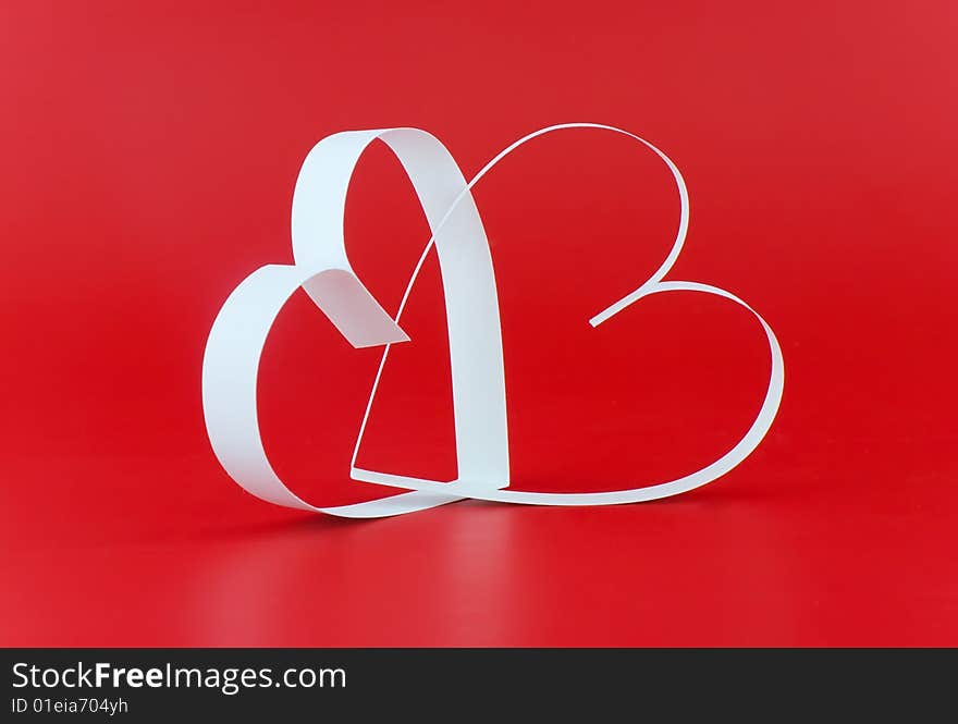 Intertwining of two hearts, on red background. Focus on a center. Intertwining of two hearts, on red background. Focus on a center.