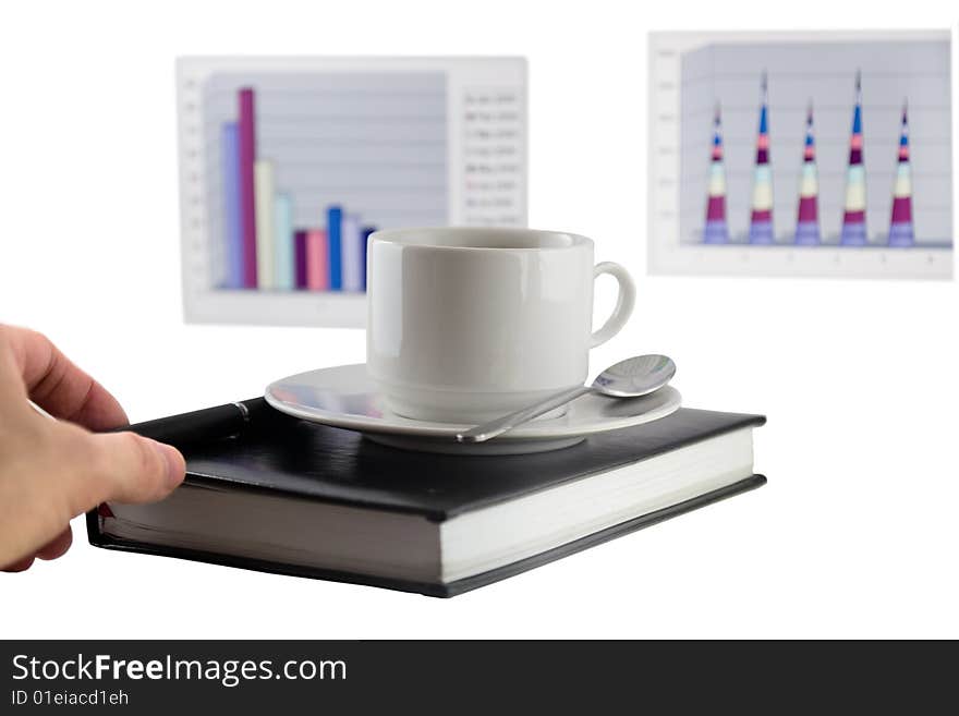 Coffee cup, standing on the black personal organizer, on a back background - two financial  diagrams . Isolated on white. Coffee cup, standing on the black personal organizer, on a back background - two financial  diagrams . Isolated on white.