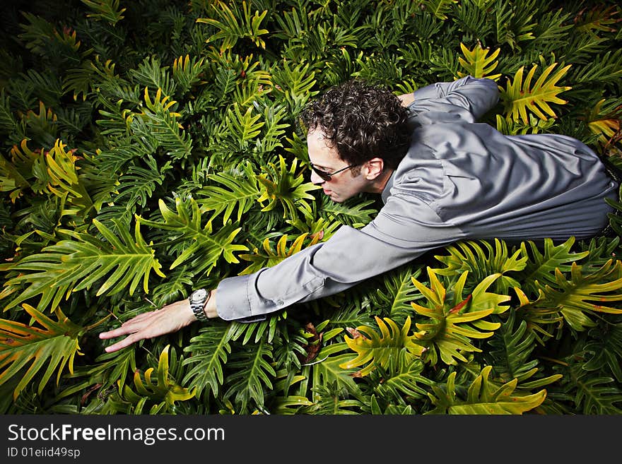 Businessman swimming through a field of green plants. Businessman swimming through a field of green plants