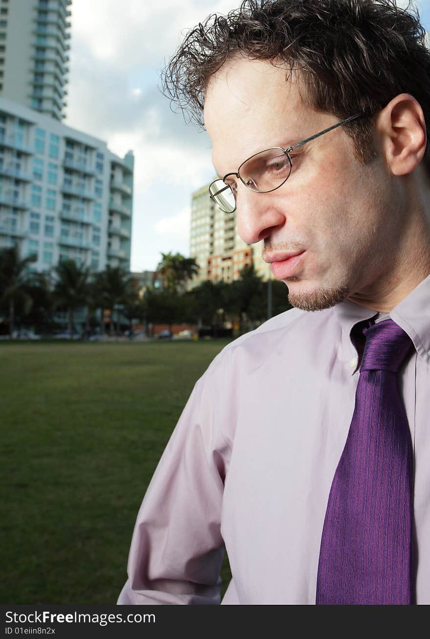 Young businessman wearing reading glasses and looking downward. Young businessman wearing reading glasses and looking downward