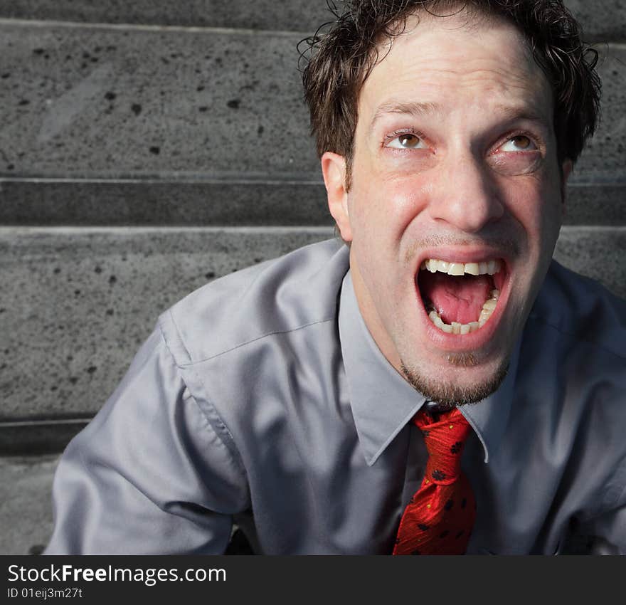 Businessman screaming and facing upward. Businessman screaming and facing upward