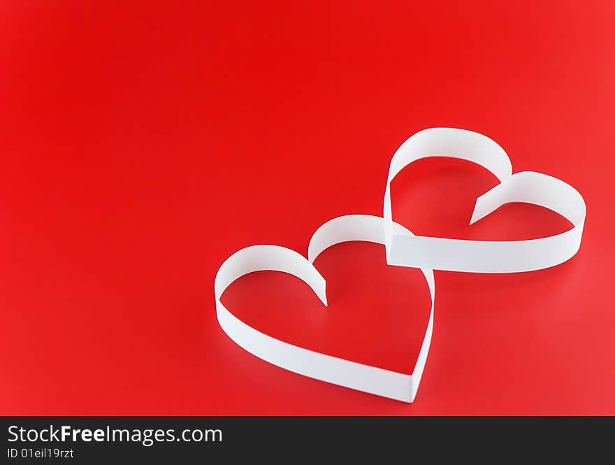 Two hearts,on red background,  laying  one on the another. Two hearts,on red background,  laying  one on the another.