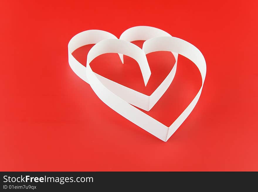 Two hearts,on red background,  laying  one on the another. Two hearts,on red background,  laying  one on the another.