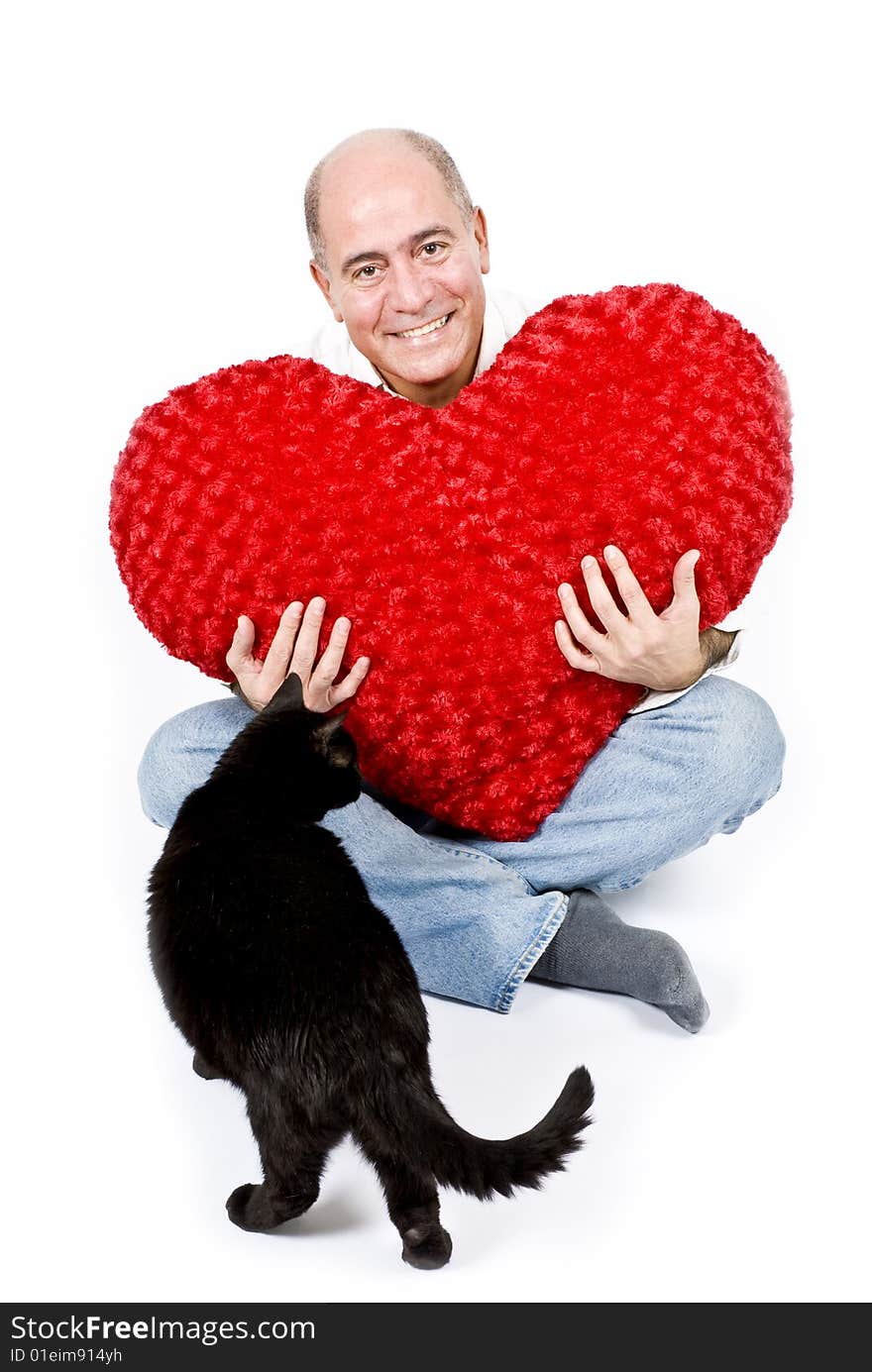 A handsome Latin man sitting holding a big red heart. A handsome Latin man sitting holding a big red heart.