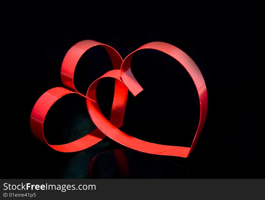 Two hearts with center spot light, on black  background. Two hearts with center spot light, on black  background.