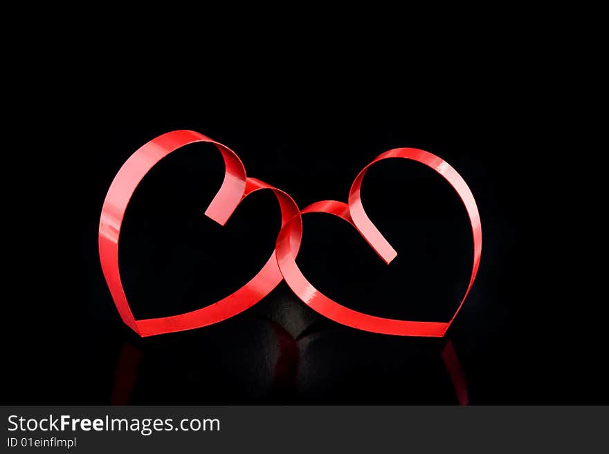 Two hearts with center spot light, on black  background. Two hearts with center spot light, on black  background.