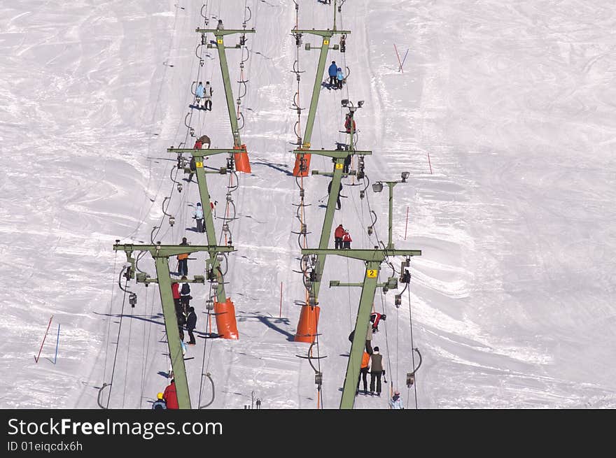 Skiers using a ski lift at a winter resort. Skiers using a ski lift at a winter resort