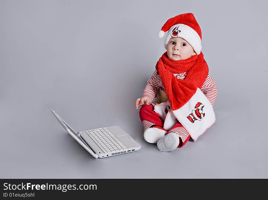 Baby santa claus with white laptop