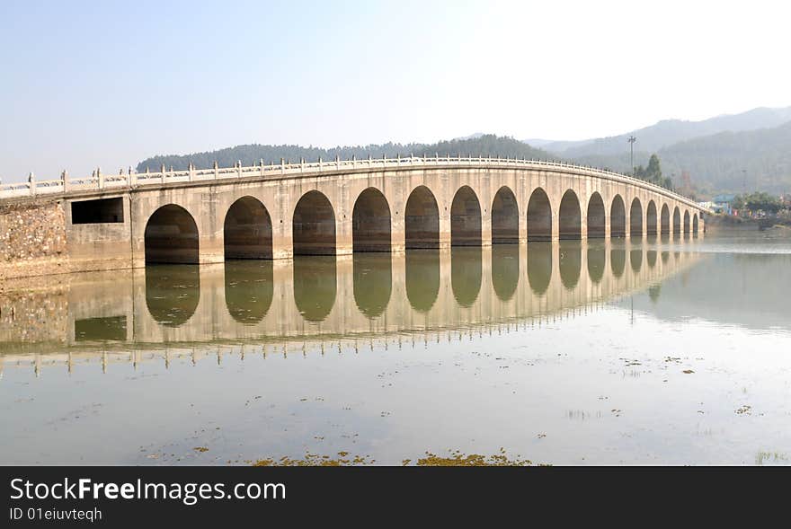 The Chinese traditional styled stone arch bridge in the lake. The Chinese traditional styled stone arch bridge in the lake.