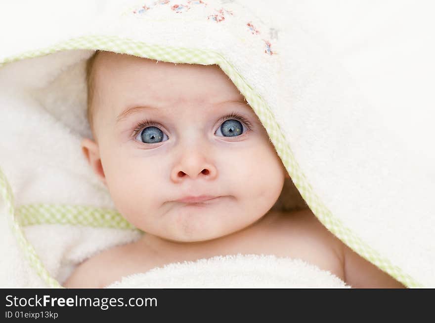 Baby girl wrapped in a white towel after bathtime. Baby girl wrapped in a white towel after bathtime