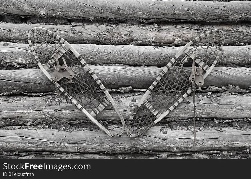 An old pair of wooden Snow Shoes hanging on a cabin wall