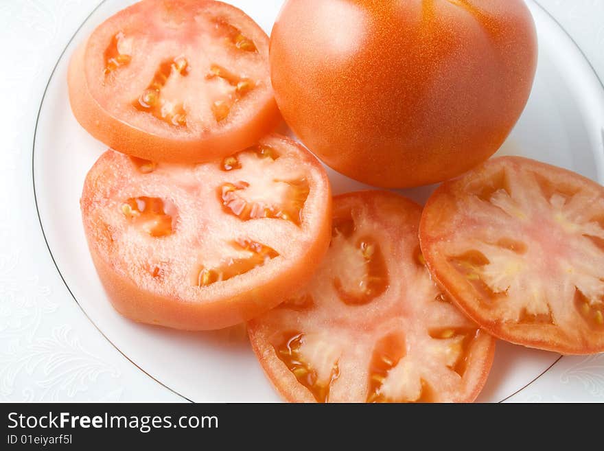 Tomato slices in dish with whole tomato