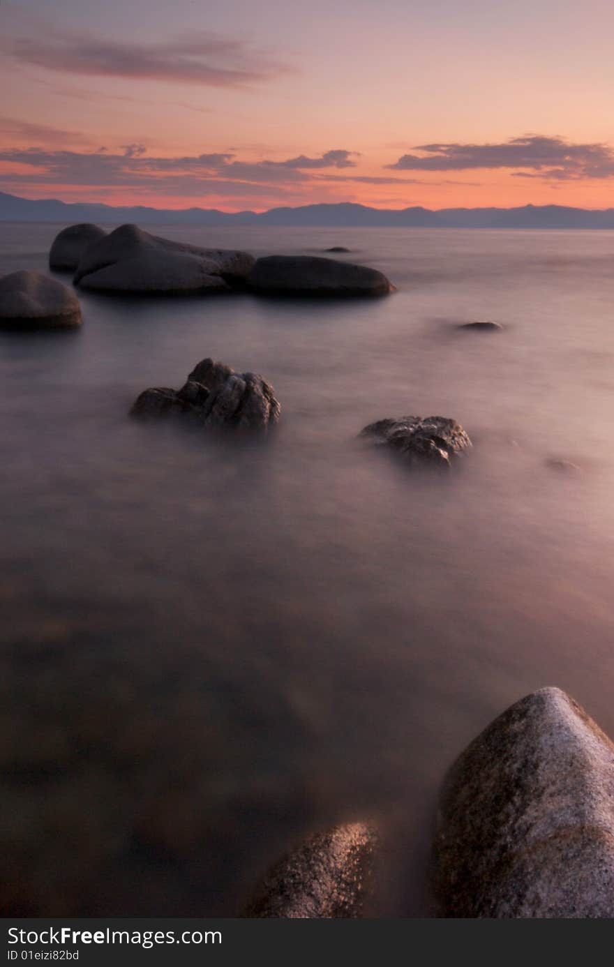 A long exposure of rocks in the surf of lake tahoe at sunset creates an unique, alien landscape. A long exposure of rocks in the surf of lake tahoe at sunset creates an unique, alien landscape