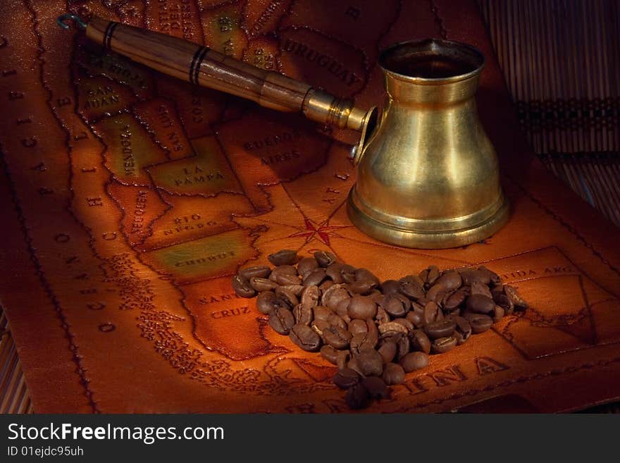 Coffee in a turk and grains on map of the South America. Coffee in a turk and grains on map of the South America