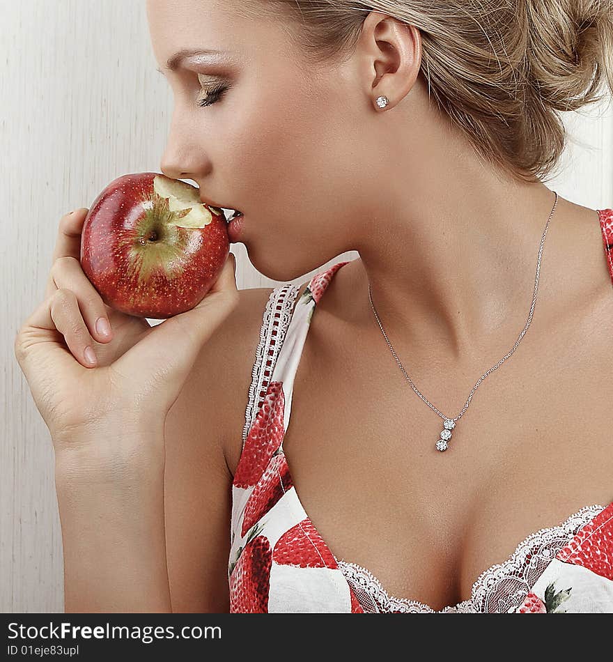 Young attractive female holding and kissing an red apple. Young attractive female holding and kissing an red apple