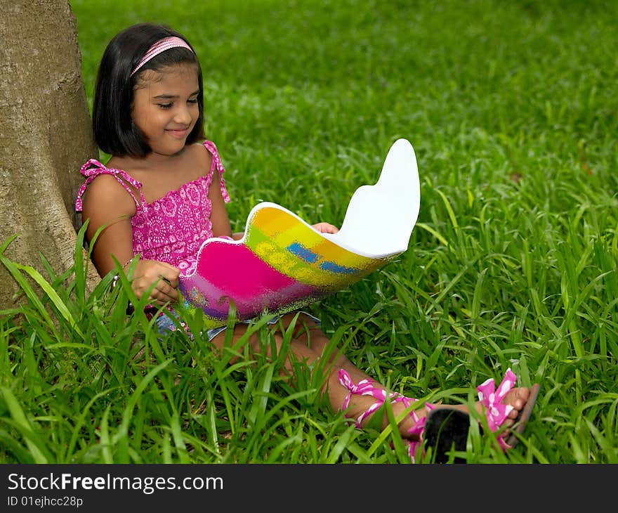 Asian girl reading a book in the park