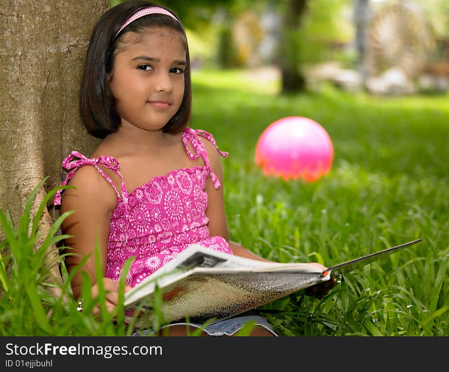 Girl Reading A Book In The Park