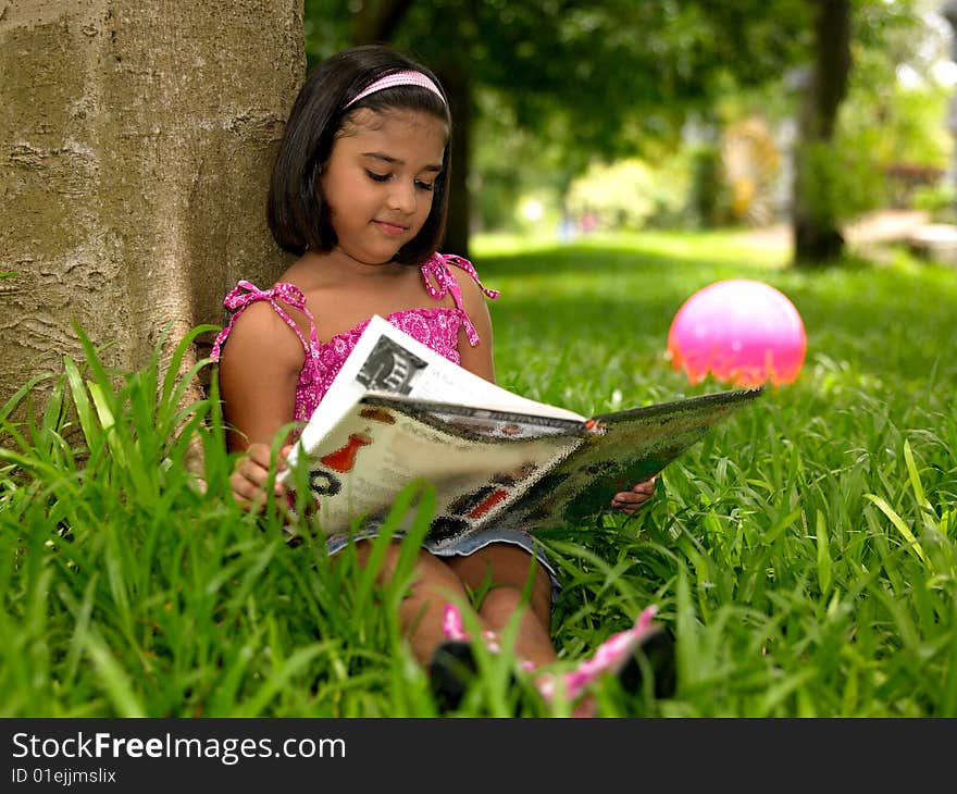 Asian girl reading a book in the park