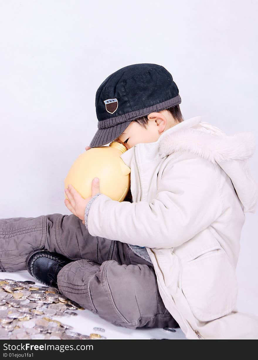 A picture of a little chinese boy playing happily with coins. A picture of a little chinese boy playing happily with coins