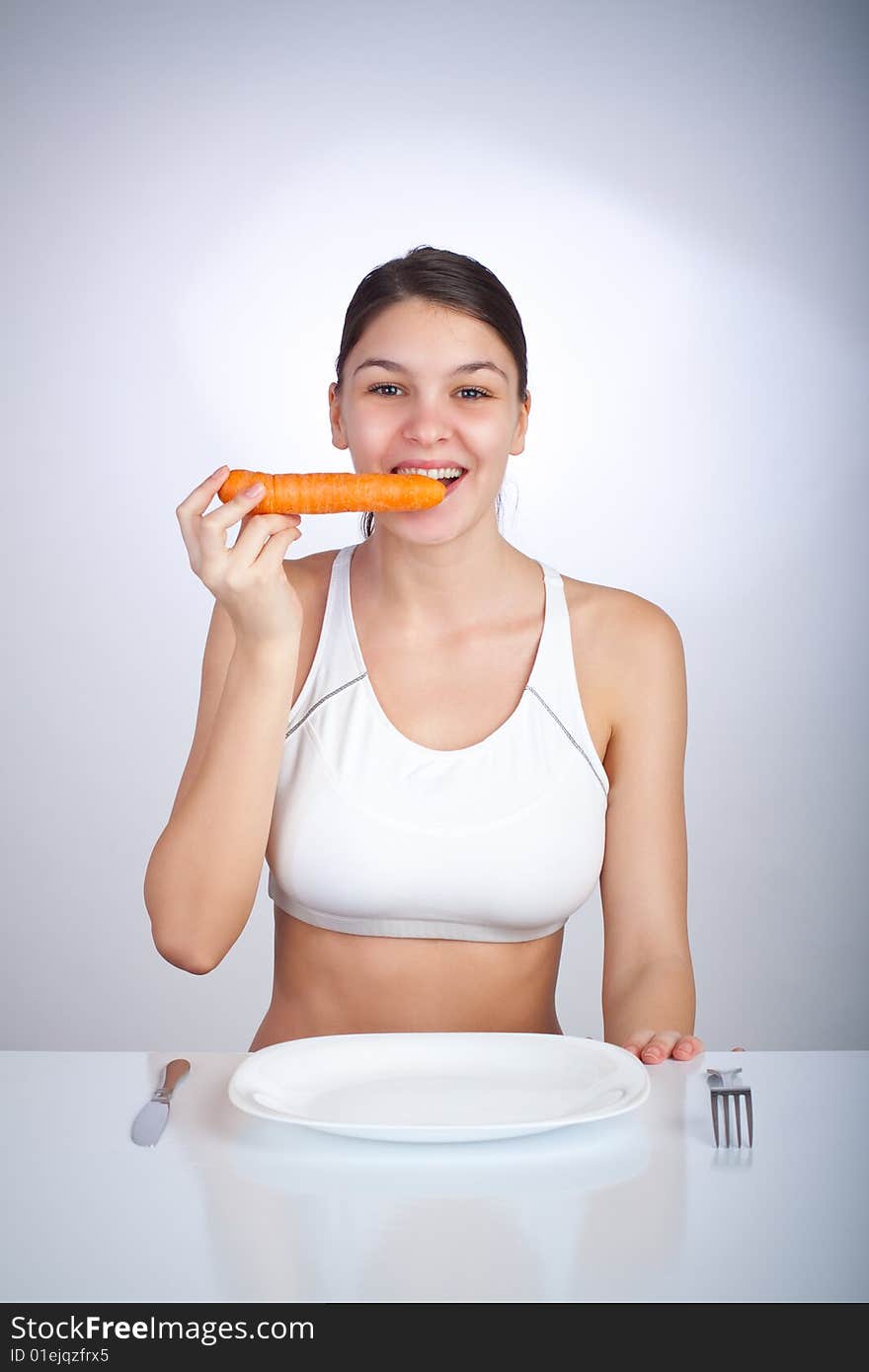 Happy woman biting a carrot. Happy woman biting a carrot