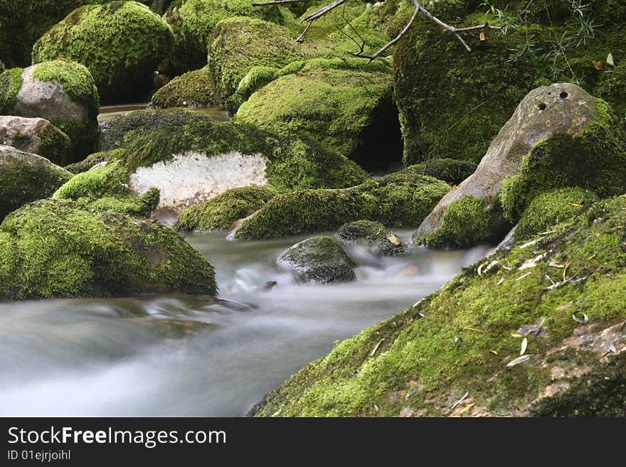 Long exposure shot of soft flowing mountain creek. Cascades of subsidiary stream of Soca river. Bovec. Slovenia. Europe. Long exposure shot of soft flowing mountain creek. Cascades of subsidiary stream of Soca river. Bovec. Slovenia. Europe