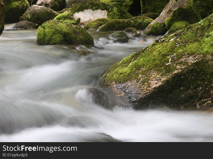 Long exposure shot of soft flowing mountain creek. Cascades of subsidiary stream of Soca river. Bovec. Slovenia. Europe. Long exposure shot of soft flowing mountain creek. Cascades of subsidiary stream of Soca river. Bovec. Slovenia. Europe