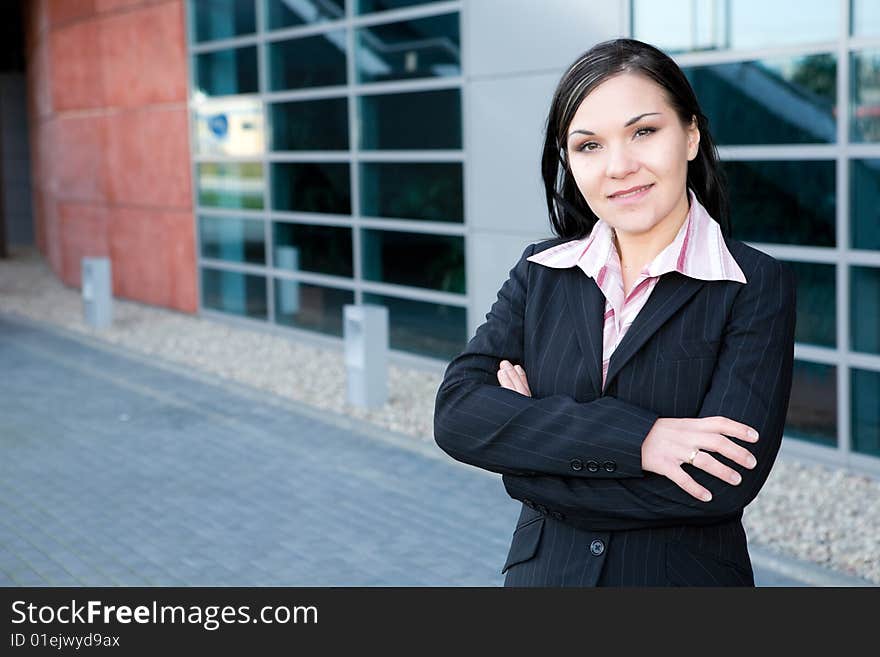 Attractive brunette businesswoman in front of office. Attractive brunette businesswoman in front of office