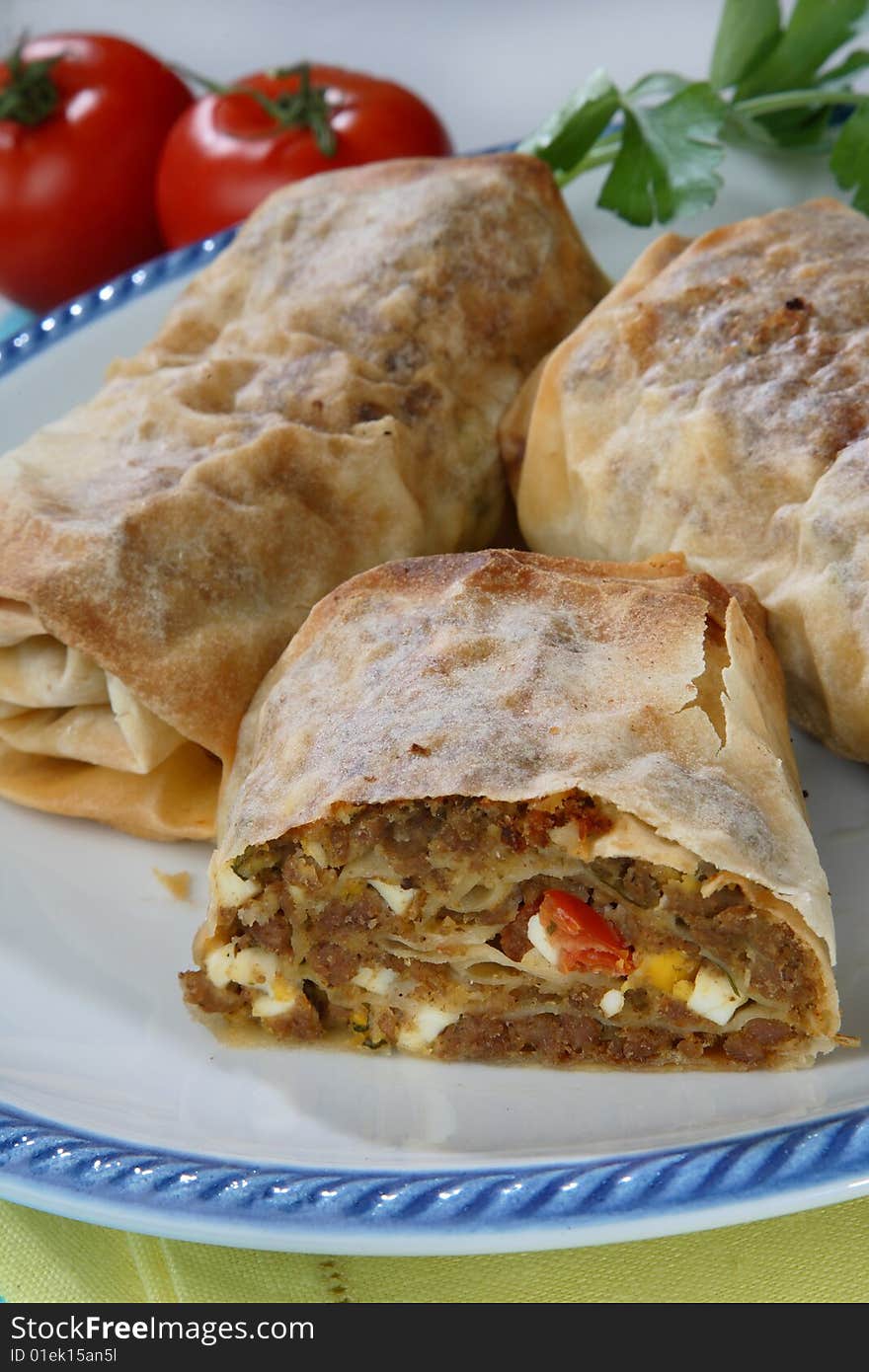 Rolled pastry with meat on plate