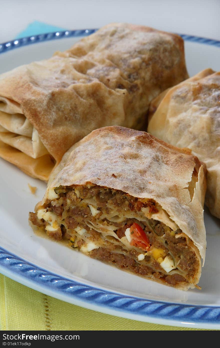 Rolled pastry with meat on plate