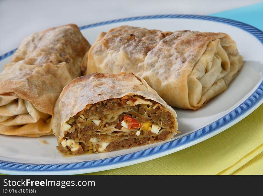 Rolled pastry with meat on plate