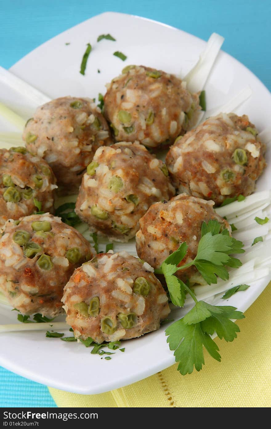 Meat balls with white rice and green peas on plate