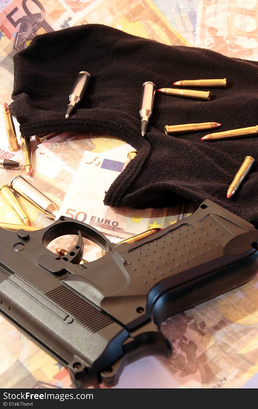 Balaclava, money, gun and bullets showing concept of a robber or terrorist activity. Balaclava, money, gun and bullets showing concept of a robber or terrorist activity