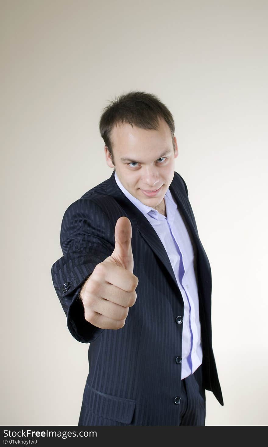 Young businessman showing thumbs up