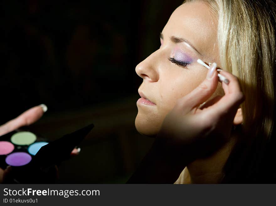 Make-up specialist working on a blond girl