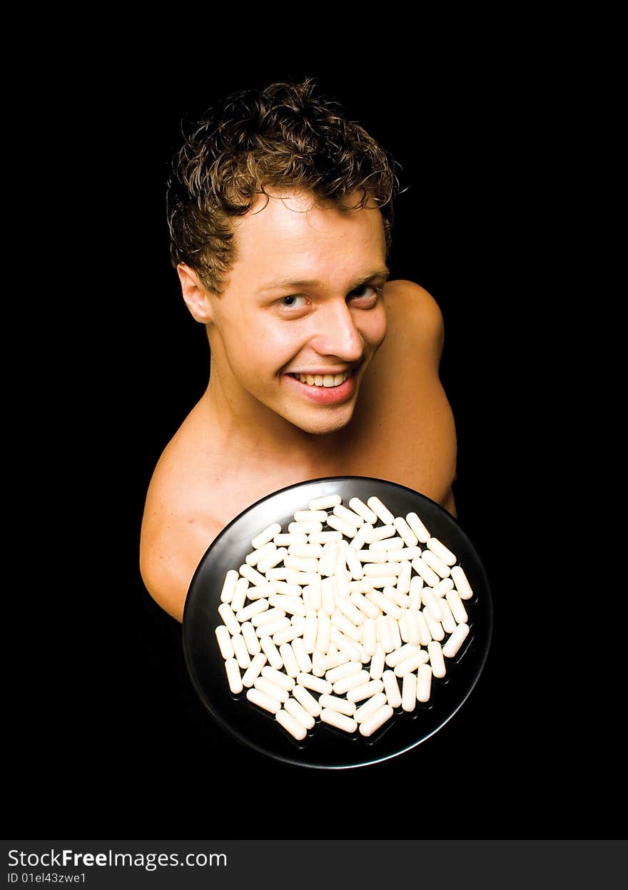 Muscular man showing medicine on an isolated black background