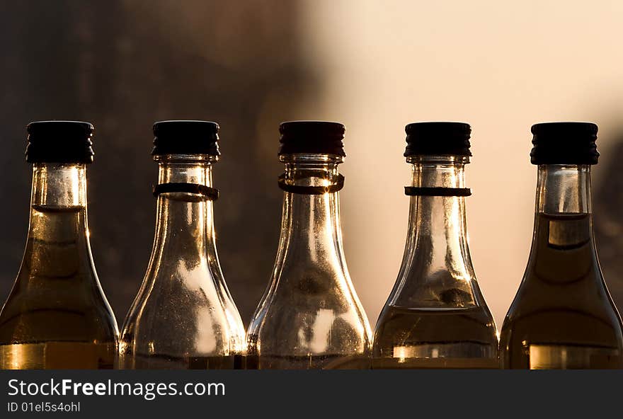 Five bottles near window at shiny evening