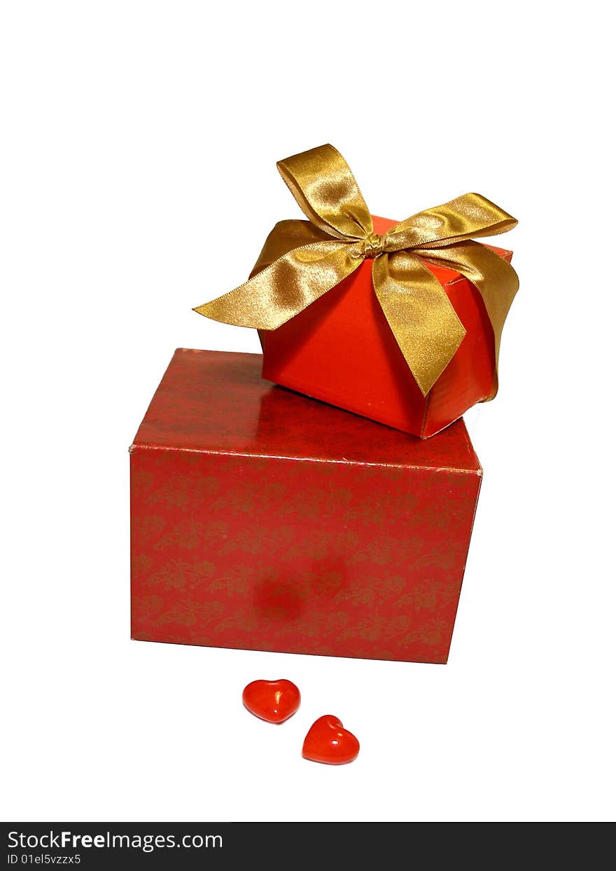 Two red gifts with a gold ribbon and two hearts isolated on a white background