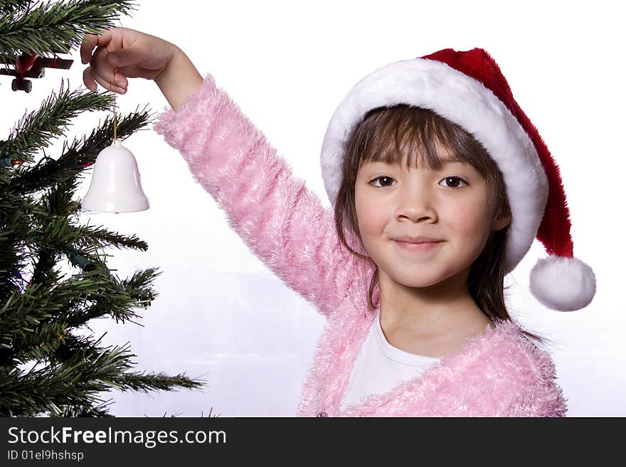 Girl holds bell next to tree.