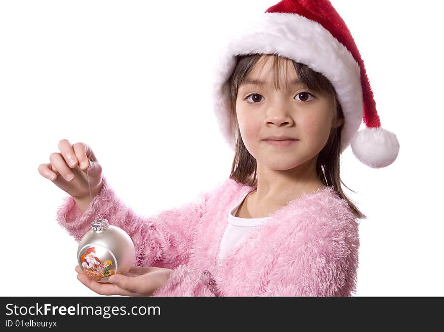 A girl with a santa hat holds a christmas ornament. A girl with a santa hat holds a christmas ornament.