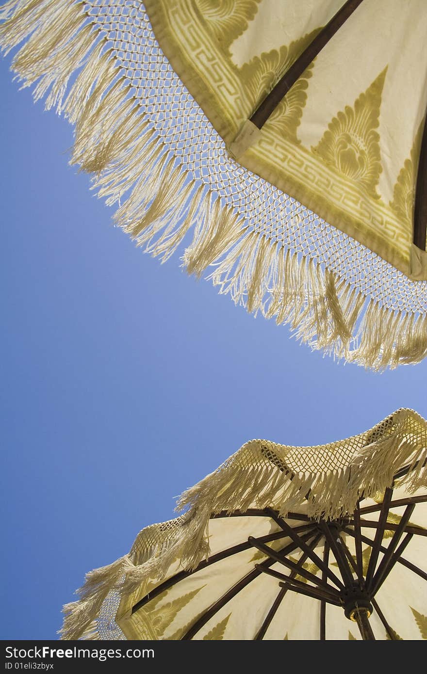 Two umbrellas on a blu sky in the summer time. Two umbrellas on a blu sky in the summer time